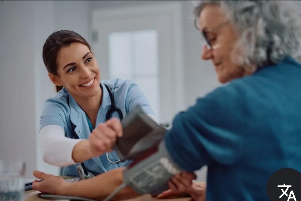 Registered nurse checking blood pressure of elderly patient at home